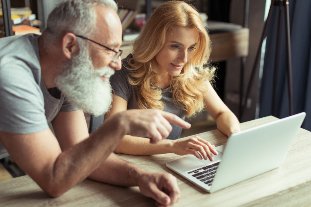 Professional couple over 50 using AI tools for business