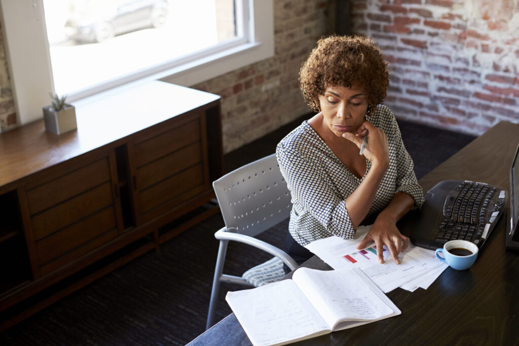 Midlife woman suffering from burnout looking at laptop 
