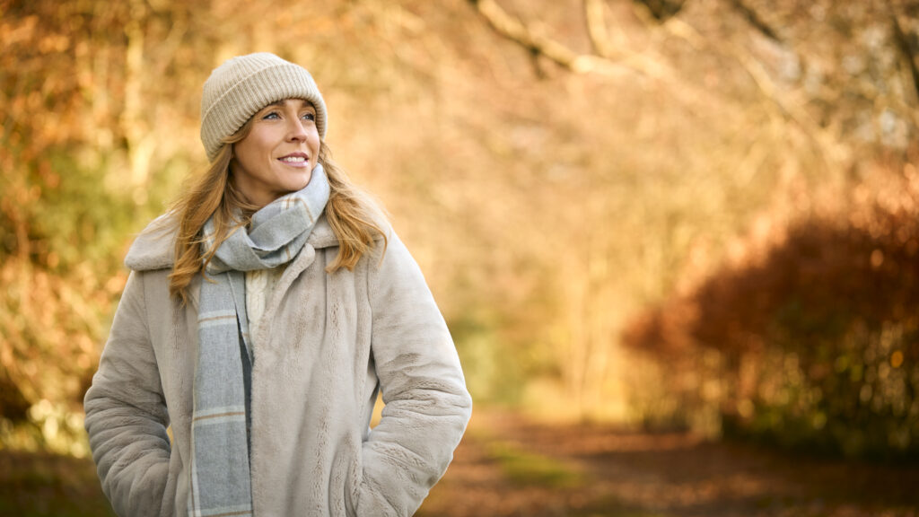 Midlife woman smiling with confidence outdoors 